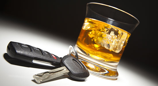 glass of liquor next to car keys