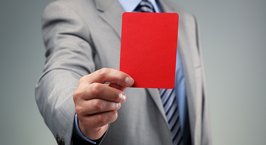 business man holds red card