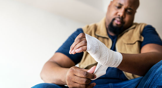 worker wrapping hand in bandage