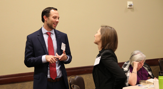 Tom Burton talks with another attendee