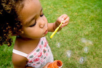 child blowing bubbles