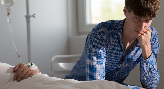 son sits next to deathbed