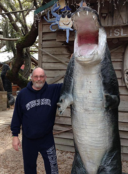 Timothy Vocke stands next to alligator
