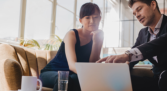 businessman and woman point to computer