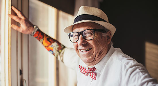 elderly man laughs playing guitar