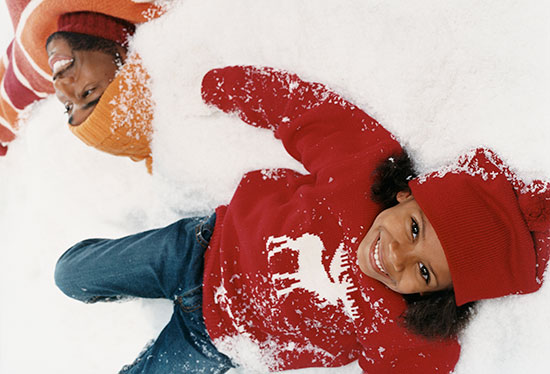 child and father playing in snow