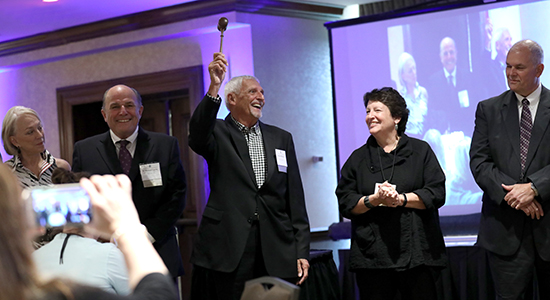 Tom Basting (center) passes the gavel.