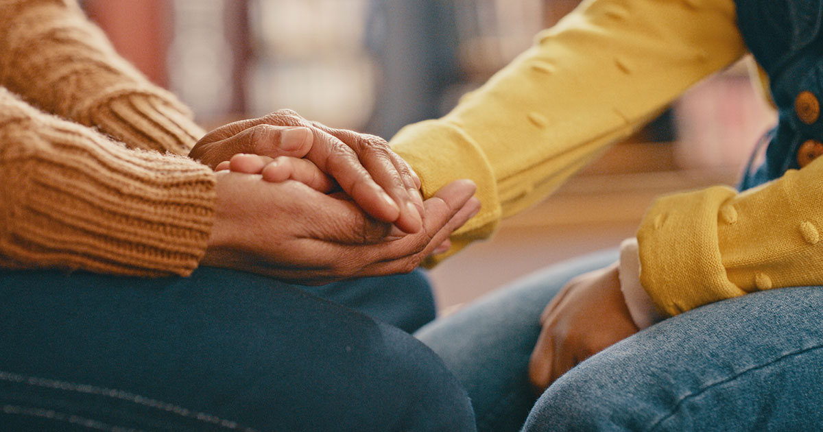 two people holding hands in a therapy session