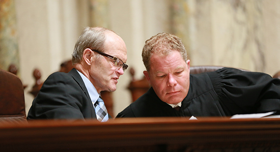 Justice Daniel Kelly, right, consults with fellow mock trial judge Kevin Lonergan during the state championship round in March.