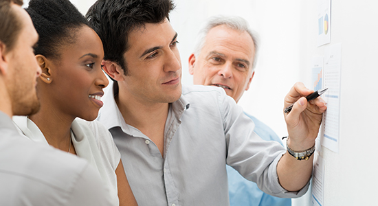 work team looks at drawing board